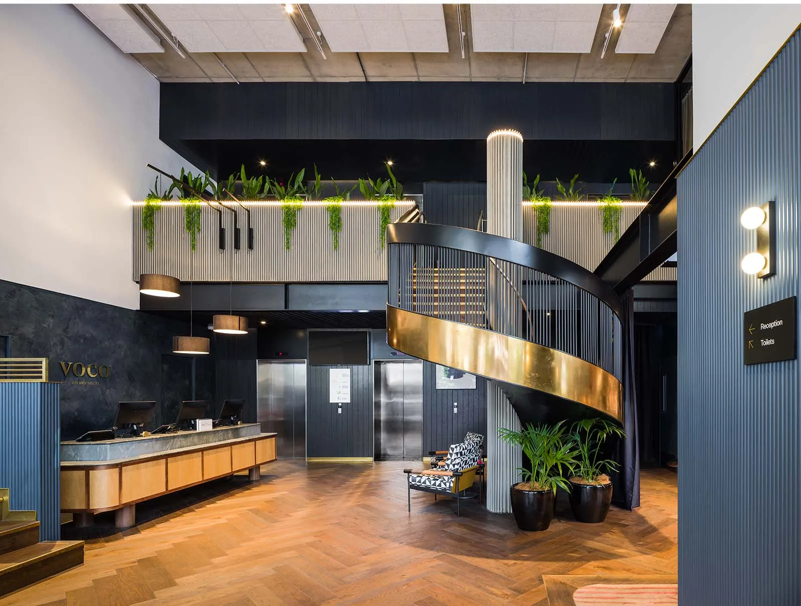 VOCO Auckland lobby with bronze spiral staircase